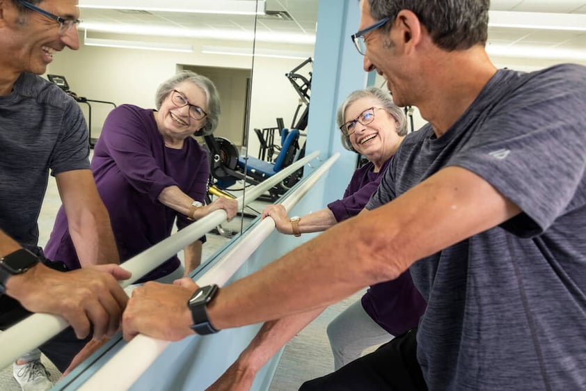 Senior woman and fitness instructor in gym